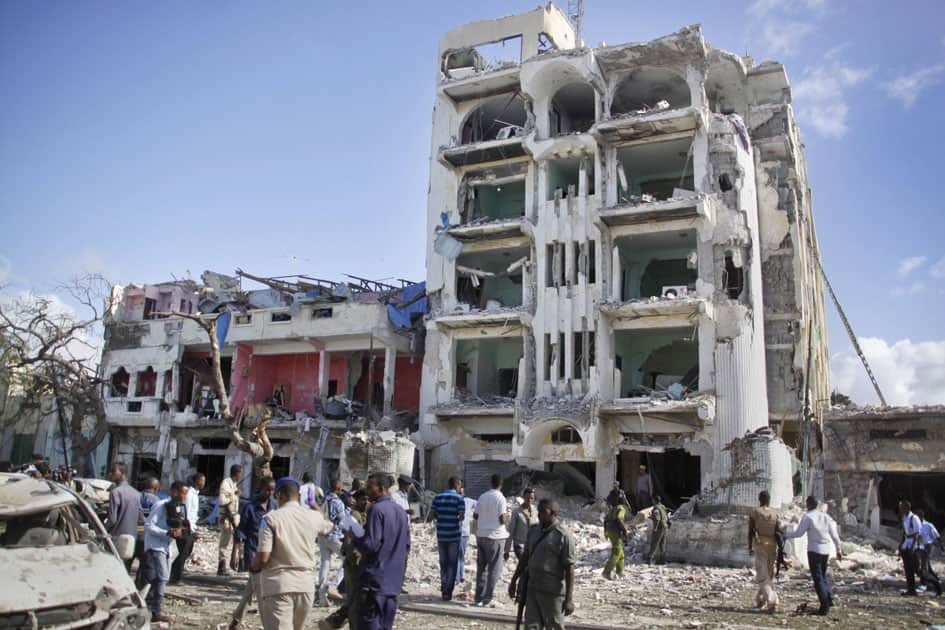 Security forces examine the scene after a bomb attack on Ambassador Hotel in Mogadishu, Somalia.