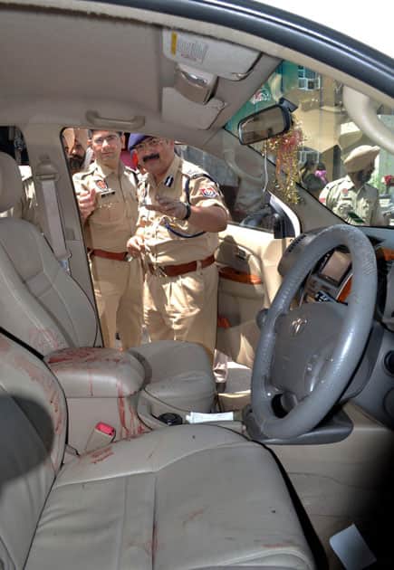 Police officers during investigation at the car of garment trader Anil Kumar who was shot dead in the vehicle in Jalandhar.