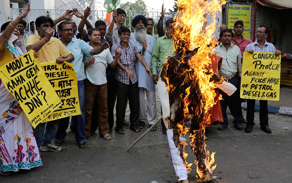 Congress party shout slogan as they burn an effigy of Indian Prime Minister Narendra Modi