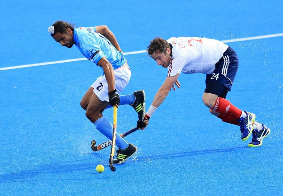 Akashdeep Singh and Great Britains Iain Lewers battle for the ball