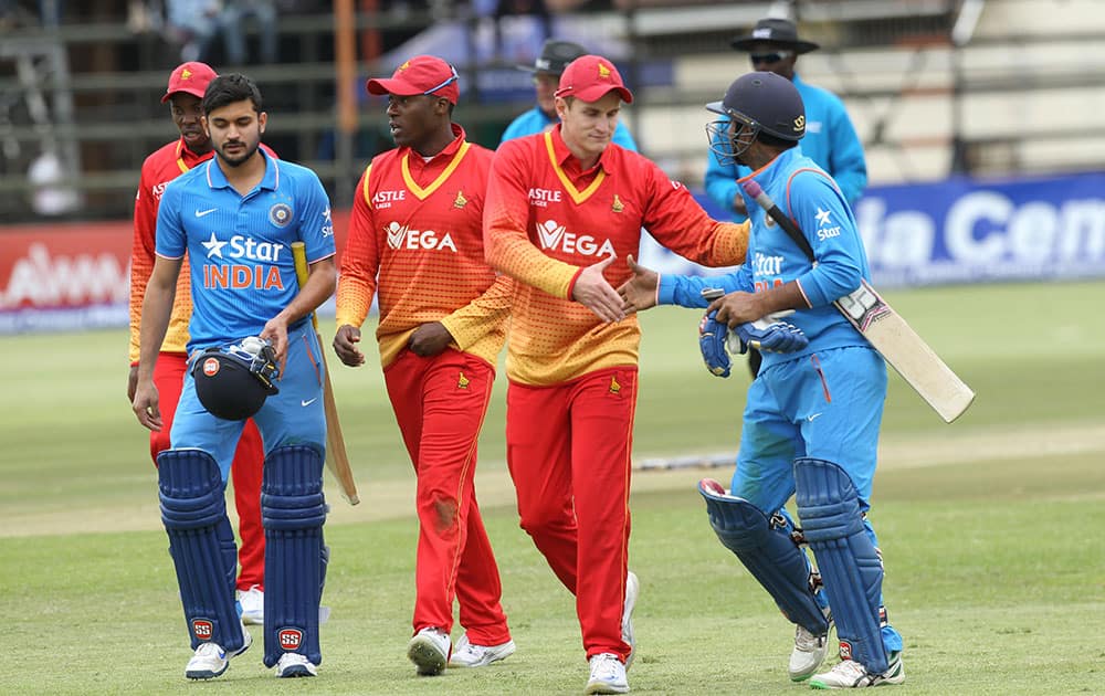 Zimbabwe and Indian cricket players shake hands at the end of the One Day International cricket match