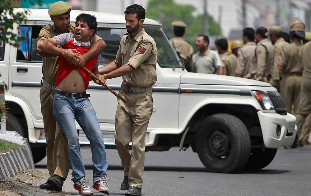 Policemen detain a protester in Jammu.