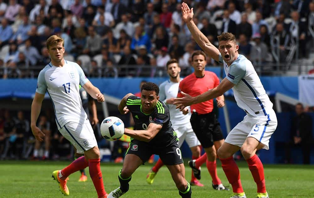 England's Gary Cahill, right, gestures as Wales' Hal Robson Kanu, center, runs away with the ball during the Euro 2016