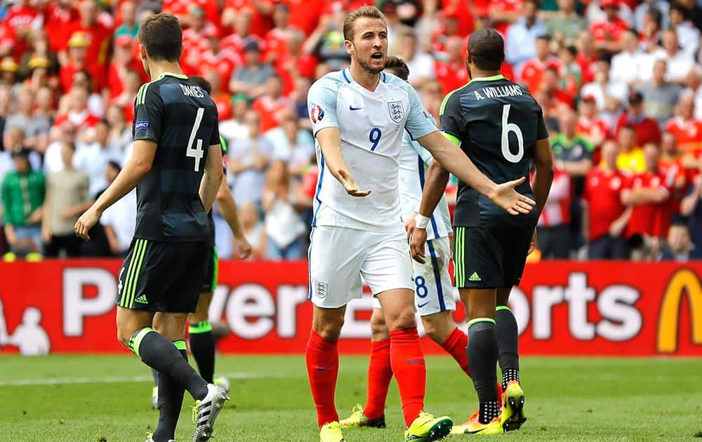 England's Harry Kane, center, calls for referee's attention as Wales' Ben Davies, left, and Wales' Ashley Williams stand beside him, during the Euro 2016