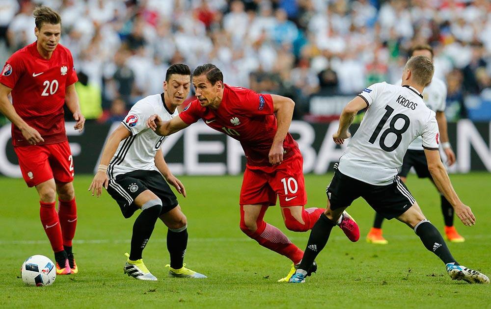 Poland's Grzegorz Krychowiak, dribbles past Germany's Toni Kroos