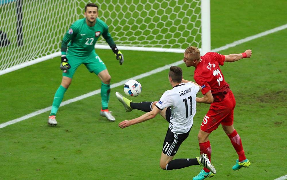 Poland goalkeeper Lukasz Fabianski looks on as Germany's Julian Draxler and Poland's Kamil Glik