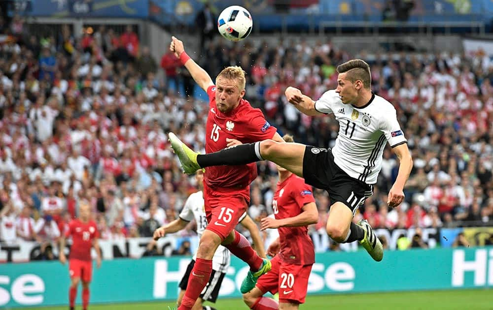 Poland's Kamil Glik, jumps for the ball with Germany's Julian Draxler during the 