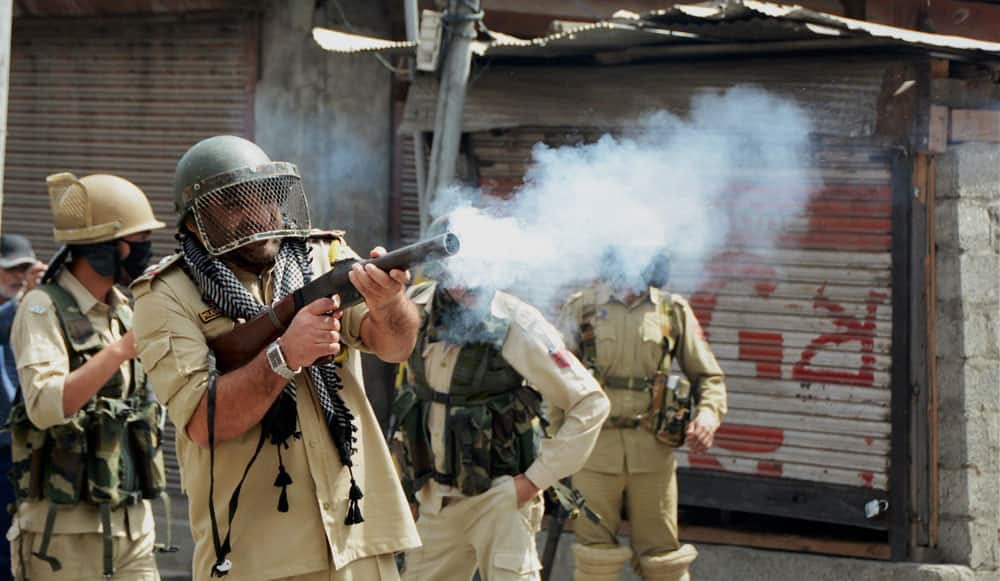 A police officer fires tear gas