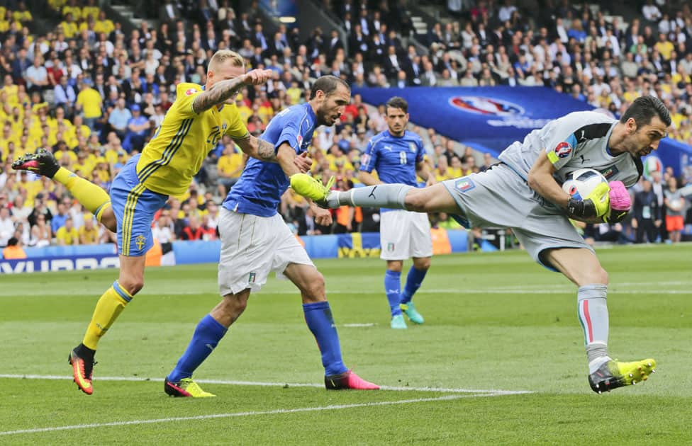 Italy goalkeeper Gianluigi Buffon grabs the ball ahead of Sweden's John Guidetti