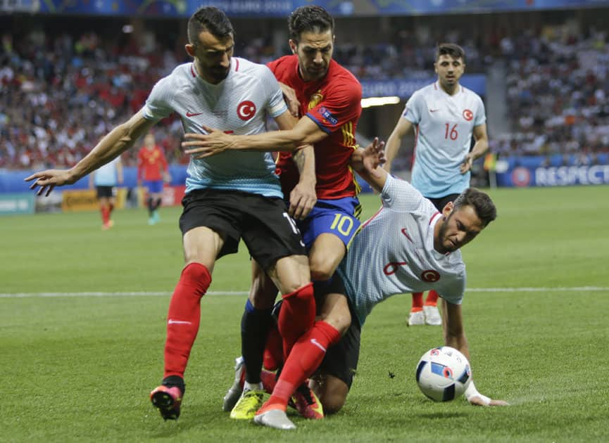 Turkey's Mehmet Topal, Spain's Cesc Fabregas and Turkey's Hakan Calhanoglu fight for the ball