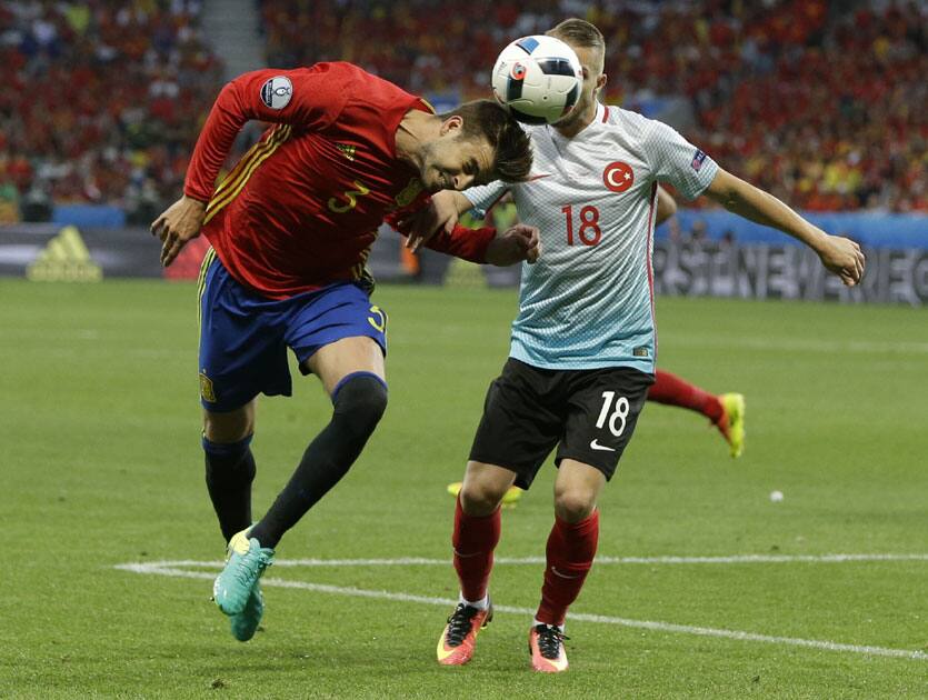 Gerard Pique and Caner Erkin go for the ball