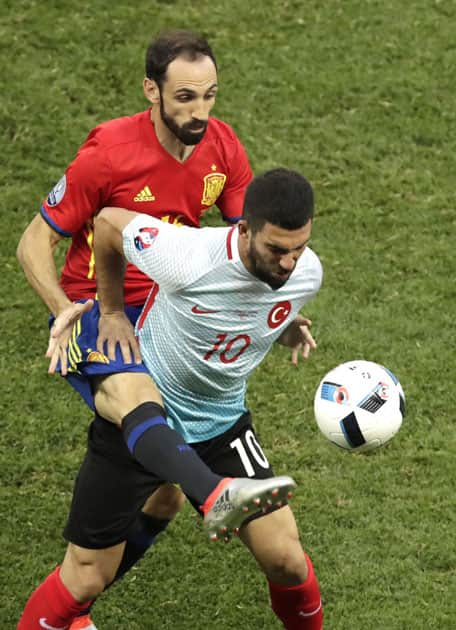 Arda Turan fights for the ball against Spain's Juanfran