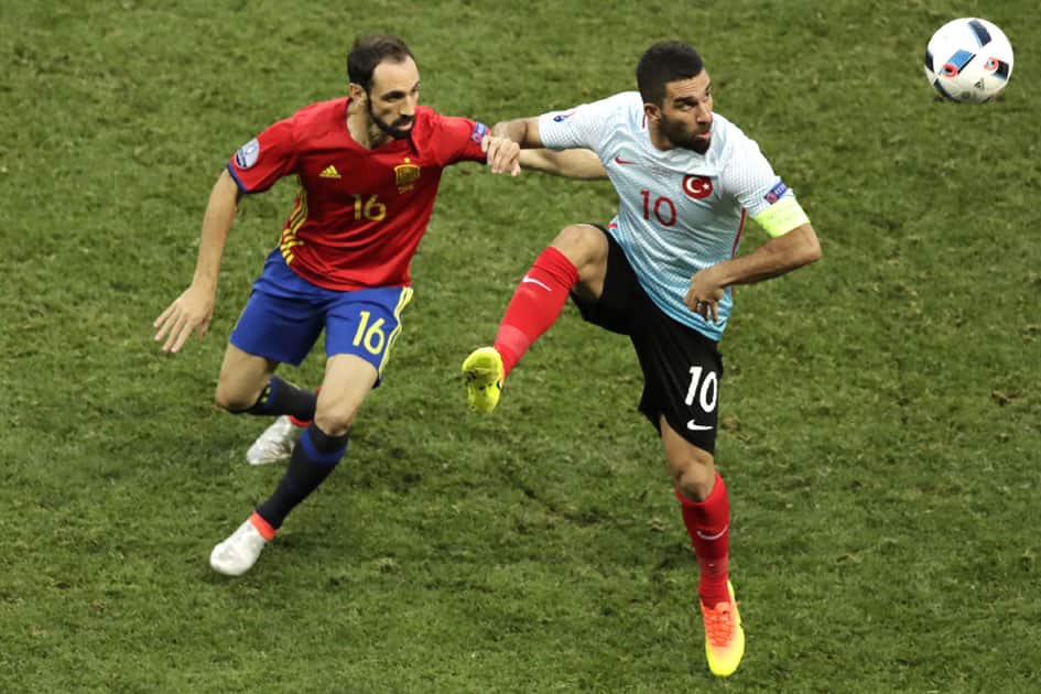 Arda Turan fights for the ball against Spain's Juanfran