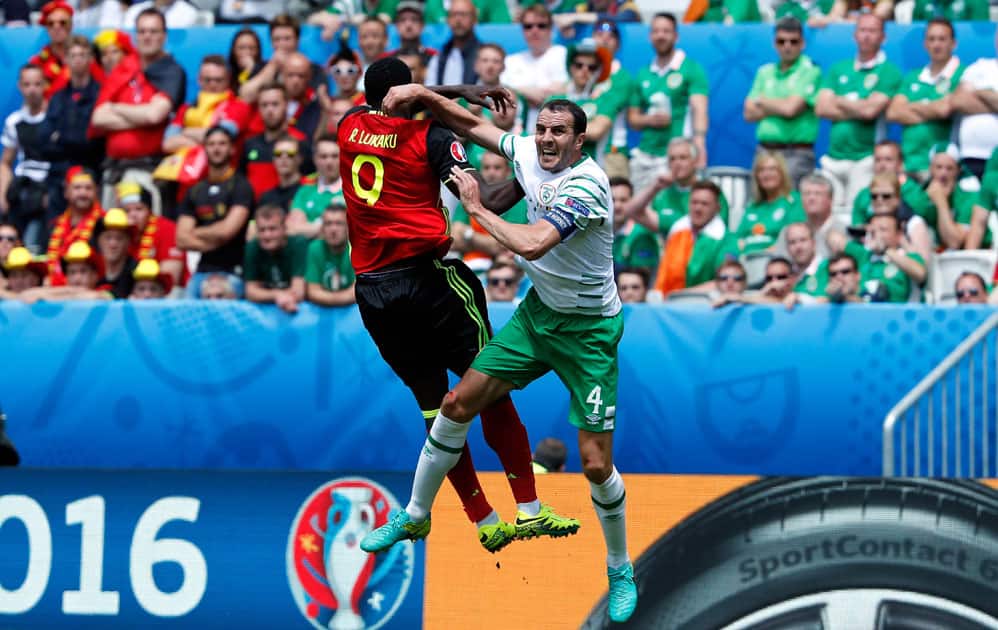 Belgium's Romelu Lukaku, left, jumps for the ball 