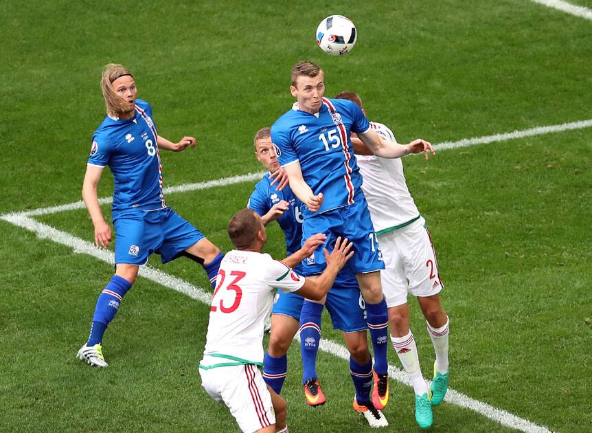 celand's Jon Dadi Bodvarsson, center, goes for a header 