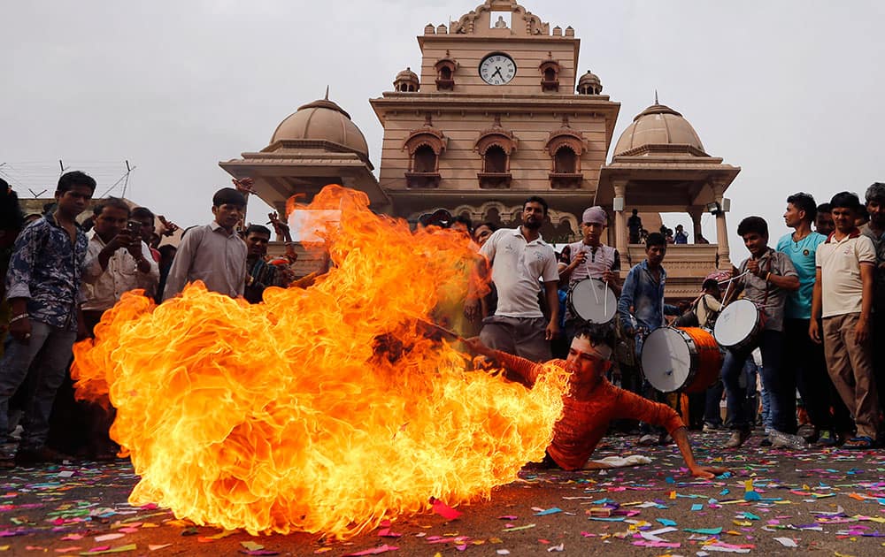 A man performs a fire stunt during a procession ahead of annual Rath Yatra
