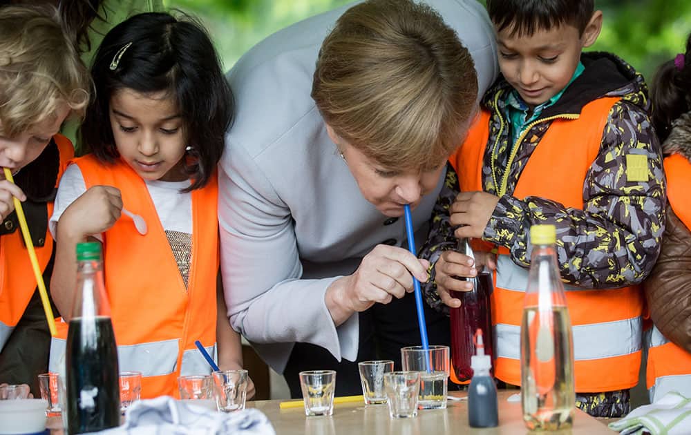 German Chancellor Angela Merkel tries lemonade mixed by children