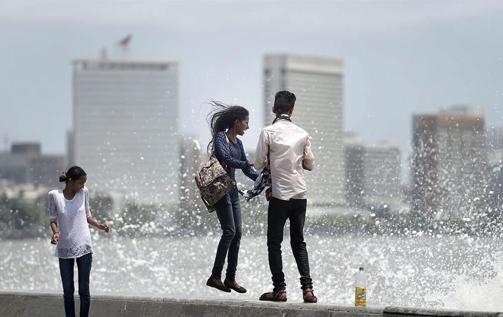Youngsters enjoy the high tide at Marine Drive promenade in Mumbai