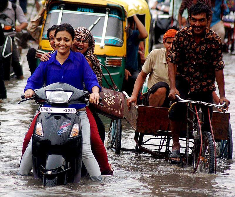 People move with their vehicles on a submerged street