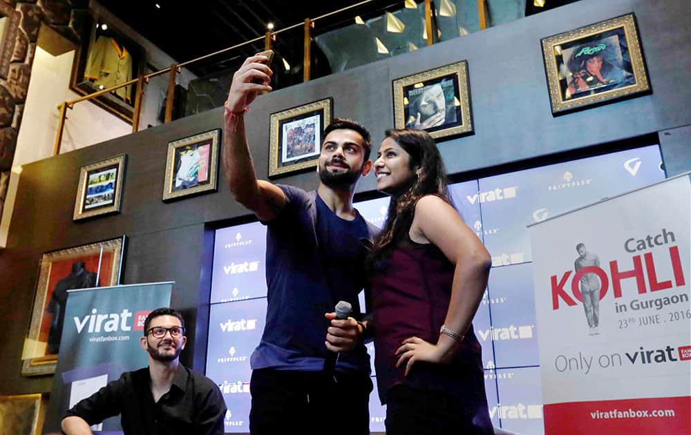 Cricketer Virat Kohli takes selfie with a fan at an event 