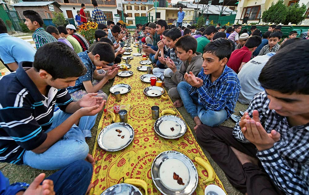 Inmates of an orphanage pray before breaking their fast on 17th day of Ramzan at Rahat Manzil Bemina.