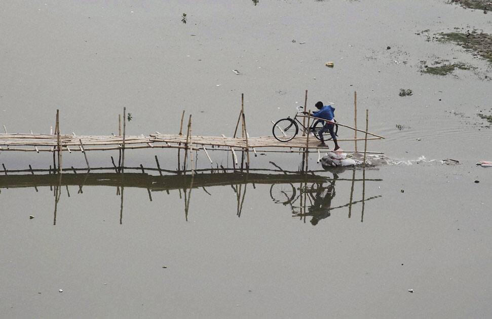 A cyclist crosses river Ganga on temporary bamboo bridge in Allahabad.