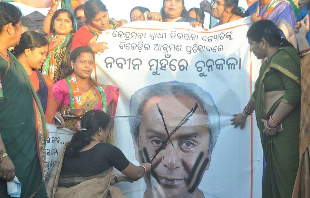 BJP activists women workers painting black ink on poster of Chief Minister Naveen Patnaik