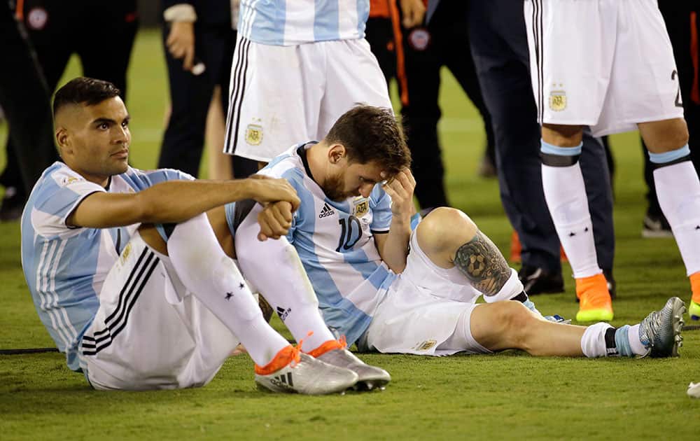 Lionel Messi sits with his teammates