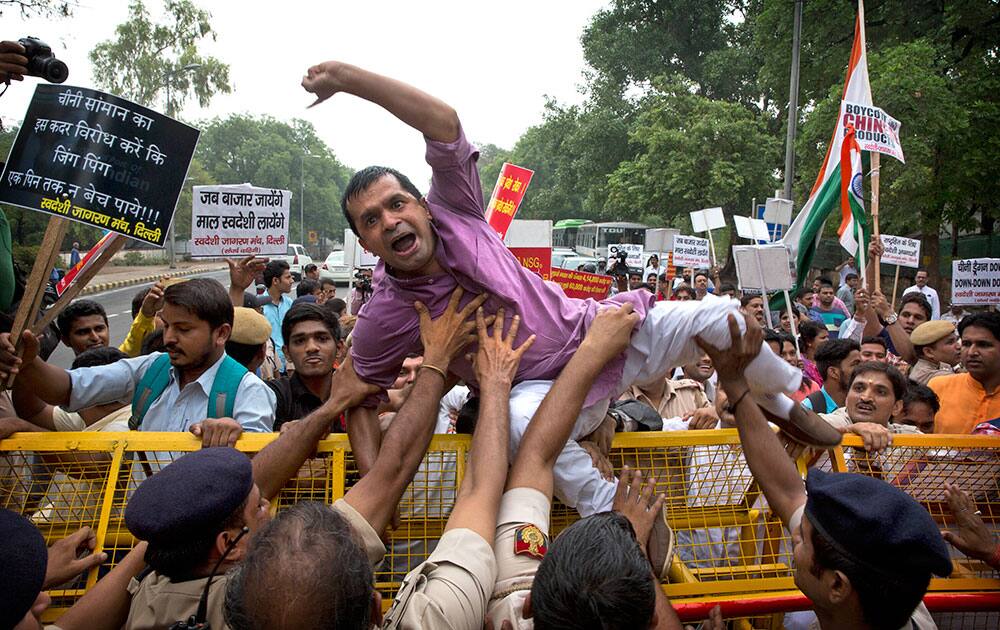 Delhi policemen stop an activist of Swadeshi Jagaran Manch