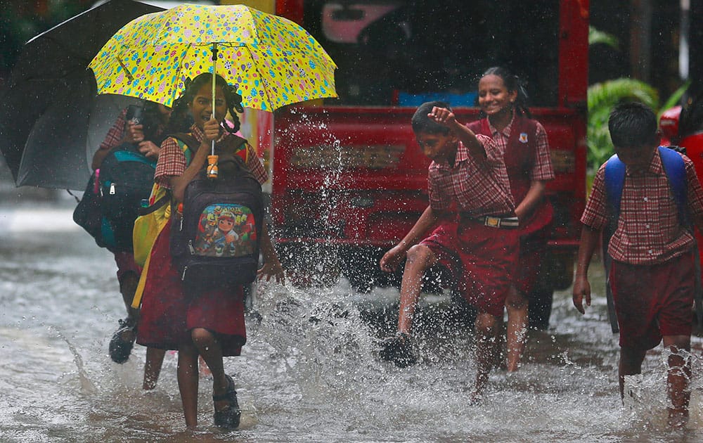 A schoolgirl reacts to rainwater being splashed on her