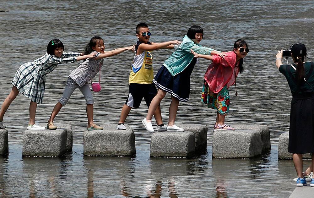 Visitors pose for their souvenir photo at the Cheonggye stream in Seoul