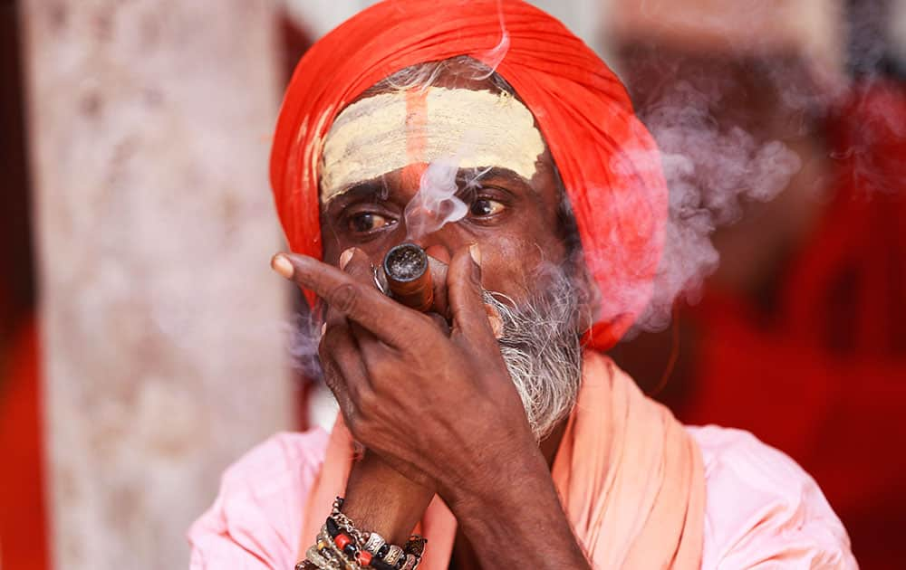 A Sadhu smokes as he waits to register for the annual Amarnath pilgrimage