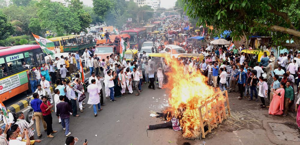 Activists and supporters of Congress party burn an affegy of inflation