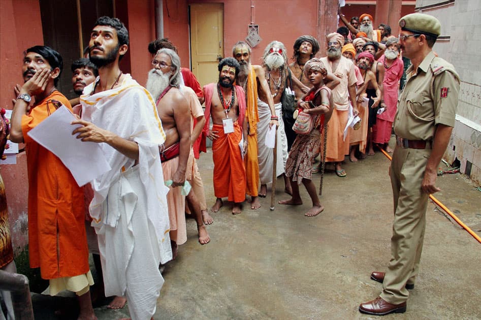 Sadhus wait in a queue to register for Amarnath