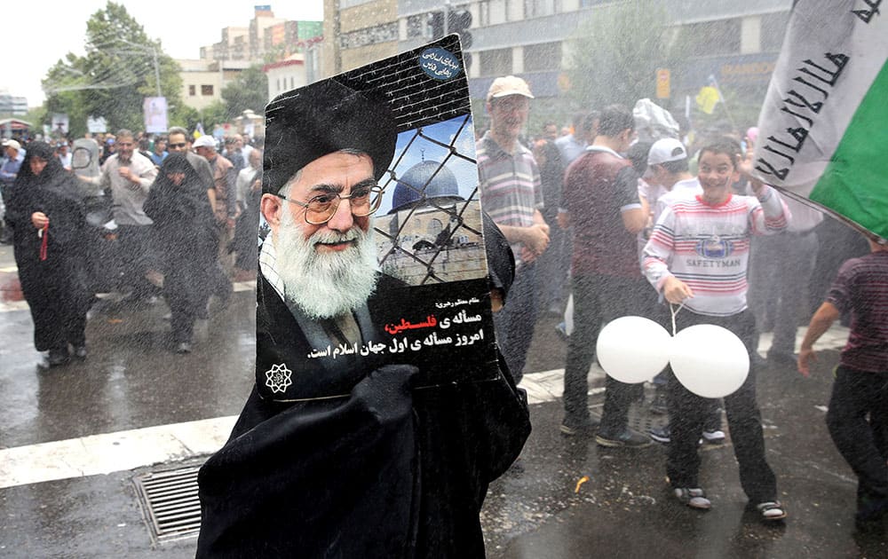 An Iranian demonstrator holds a poster showing Iranian Supreme Leader Ayatollah Ali Khamenei