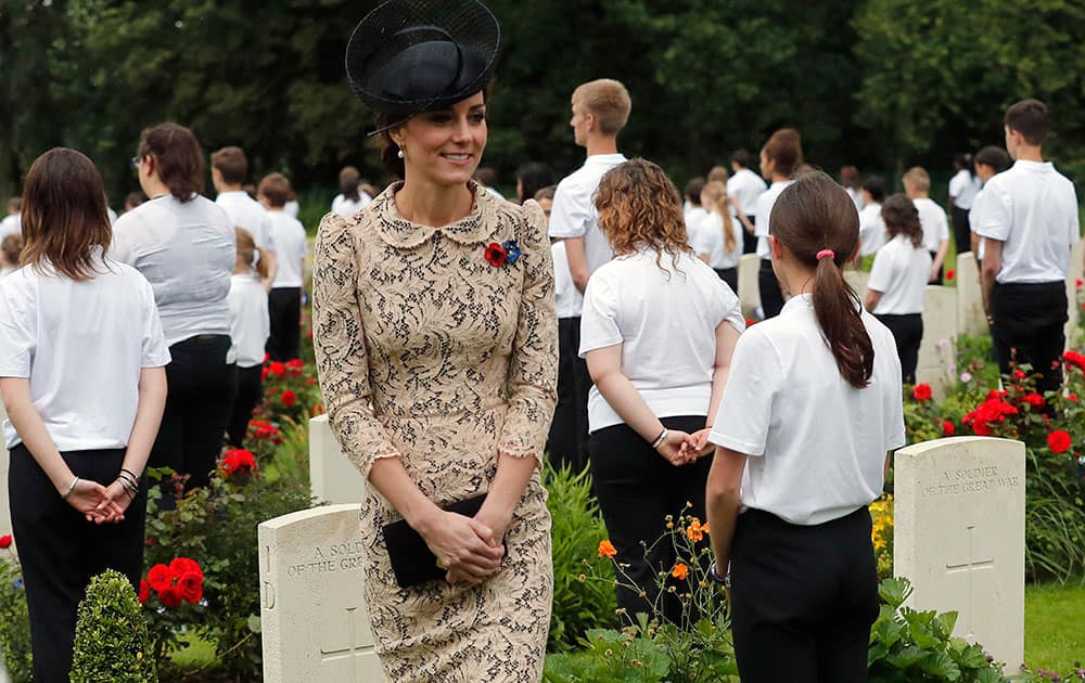 Britain's Kate, the Duchess of Cambridge smiles to volunteers in the cemetery of the World War I