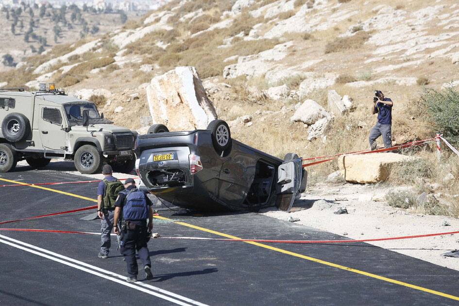Israeli policemen walk at the scene of a shooting attack near Hebro