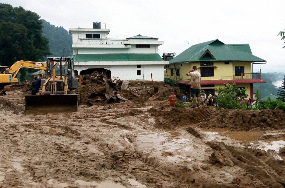 Workers busy in cleaning the debris of massive landslide