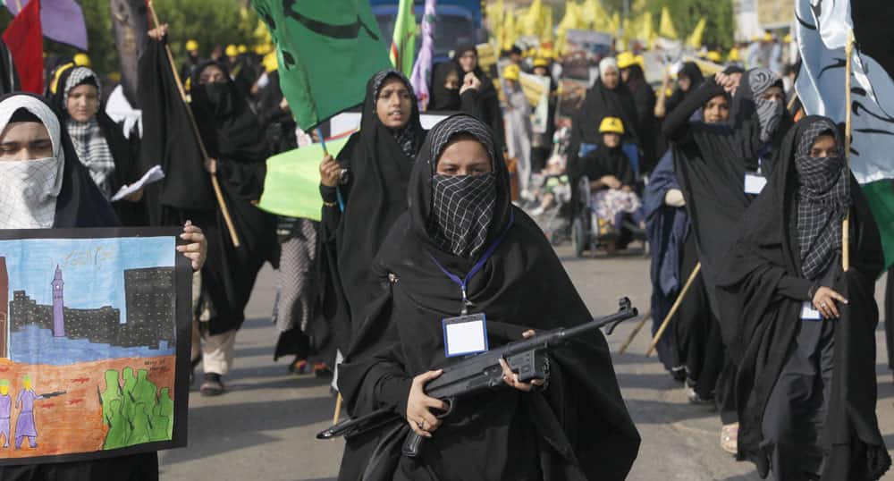 A Shiite Muslim woman holds a toy gun