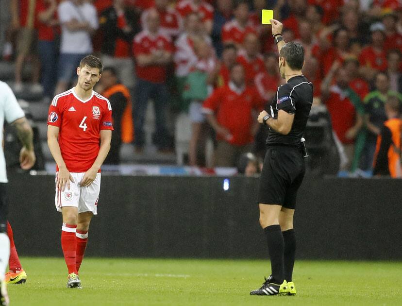 Ben Davies is booked by referee Damir Skomina