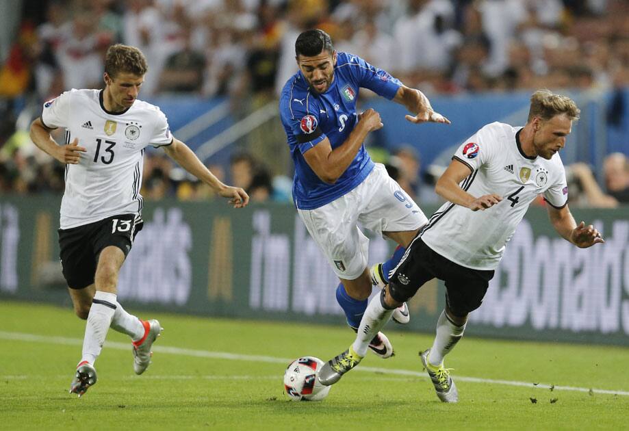 taly's Graziano Pelle stumbles over Germany's Benedikt Hoewedes