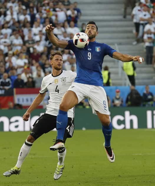 Italy's Graziano Pelle, right, and Germany's Benedikt Hoewedes go for the ball