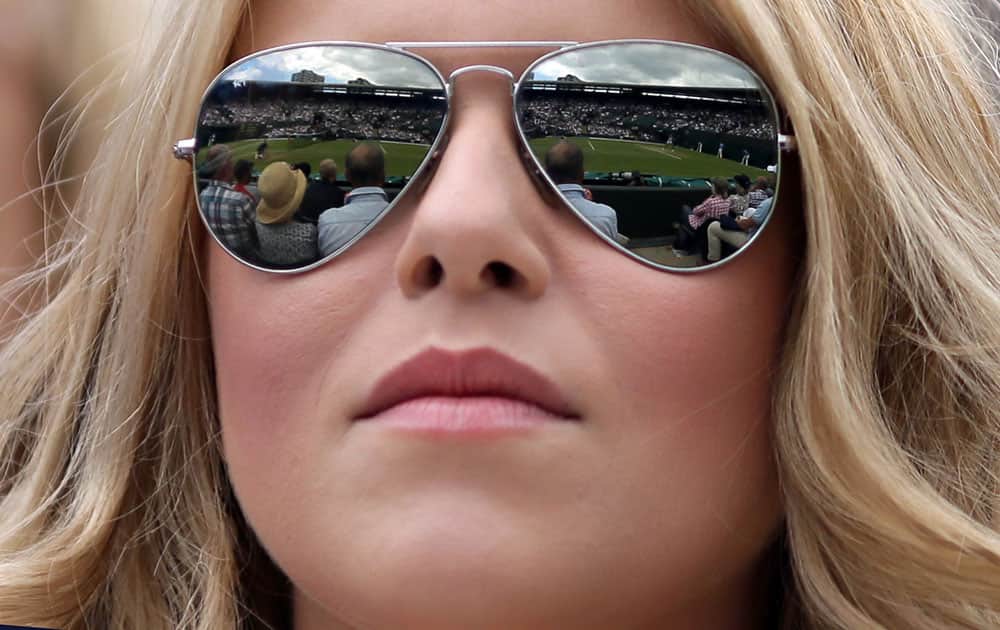 The action is reflected in a spectator's sunglasses during Wimbledon Tennis Championships in London