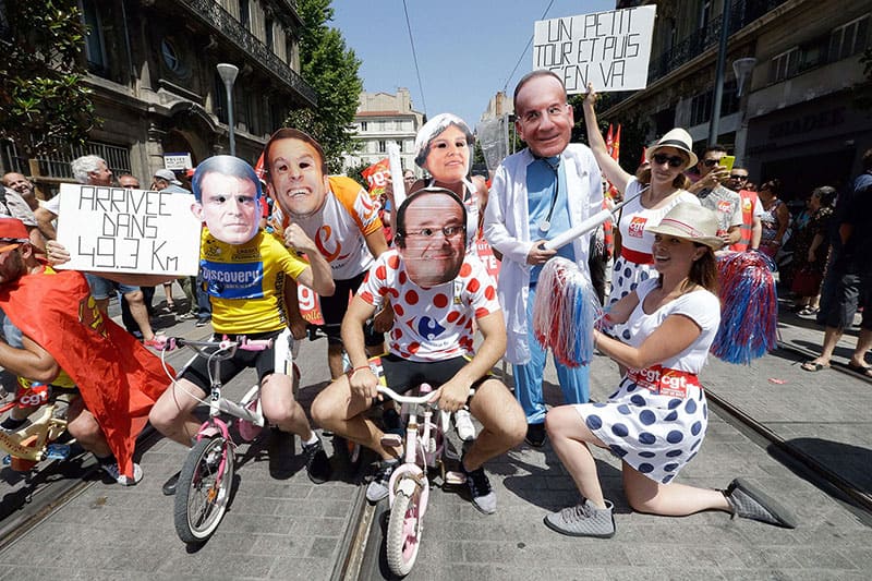 Protestors wearing masks dressed as Tour de France riders on childrens bikes, demonstrate in Marseille