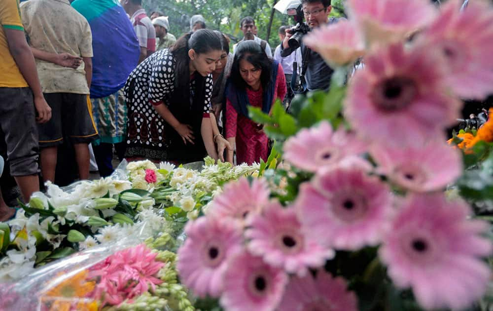 People offer flowers to pay their respects to the victims of the attack on Holey Artisan Bakery, in Dhaka