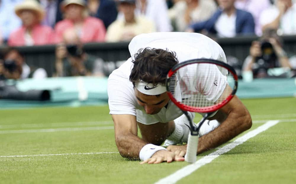 Roger Federer of Switzerland falls over