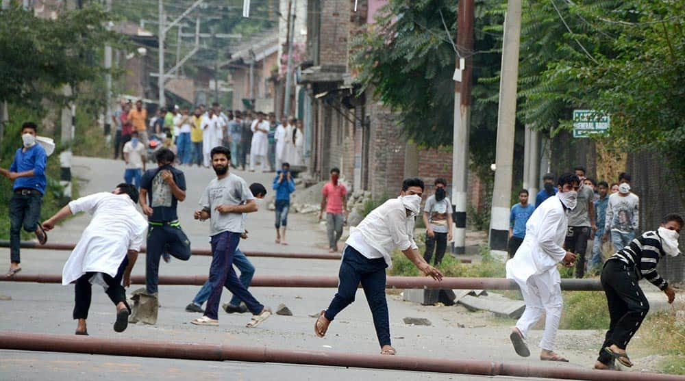 Youth throwing stones on the security forces during a clash in Srinagar.