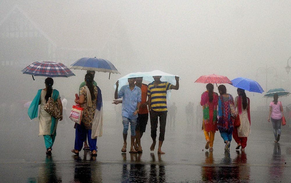 Tourists trying to protect themselves during heavy rainfall in Shimla.