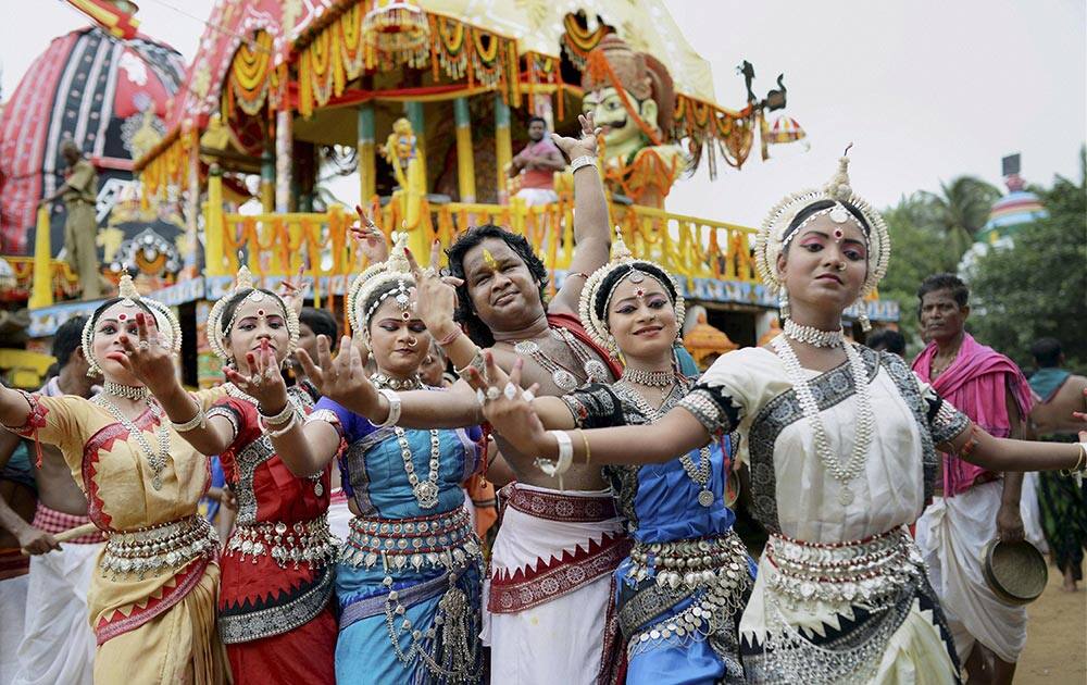 Artists dance near the three chariots