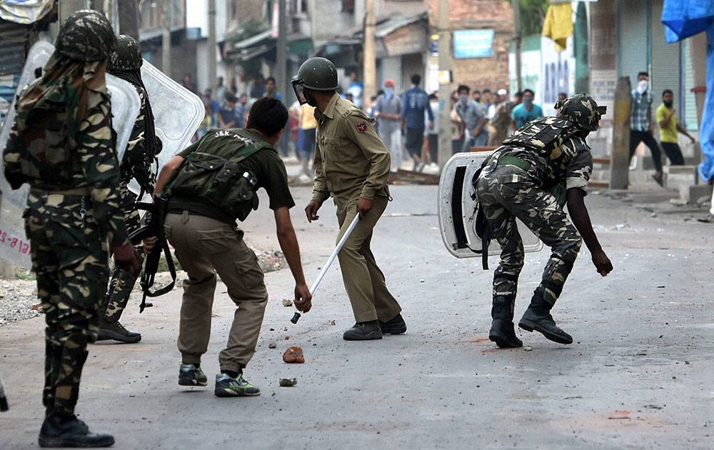 Security jawans chashing away stone throwing youths during a clash in Srinagar.